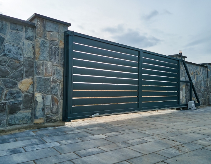 Portail coulissant contemporain entre deux murs en pierre