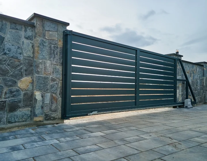 Portail coulissant contemporain entre deux murs en pierre
